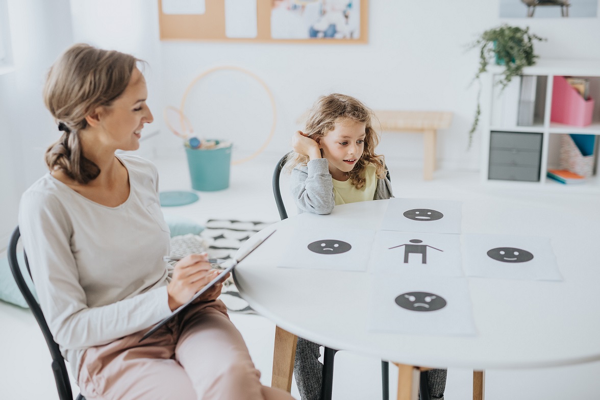 Young school psychotherapist helping the boy express emotions